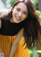 A woman with long brown hair smiling at the camera.