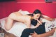 A man and a woman laying on top of a bed.