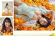 A woman laying on top of a bed covered in oranges.