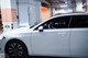 A woman sitting in the driver's seat of a white car.