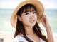 A woman wearing a straw hat on the beach.